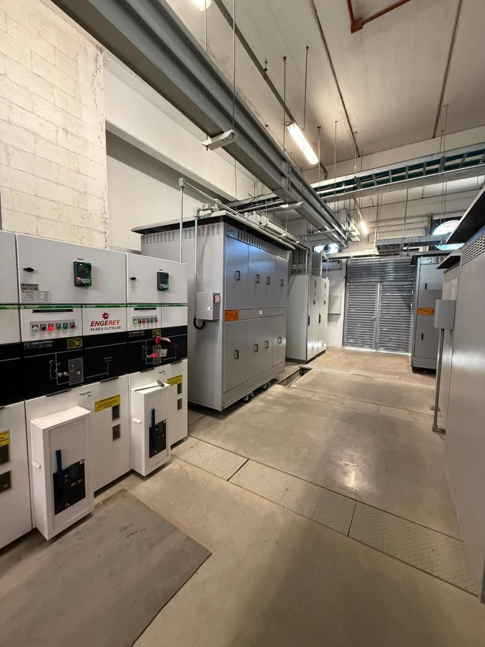 Corredor da subestação com cubículos de média tensão e transformadores a seco