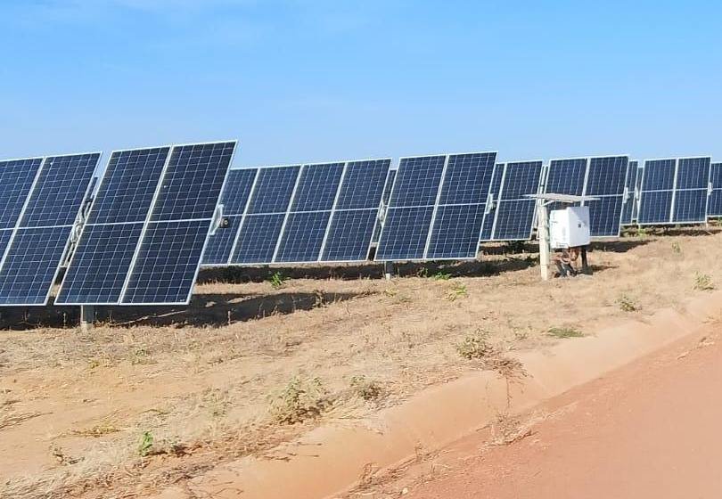 Fileiras de placas solares e caixa de conexão no campo da usina em Arinos (MG)